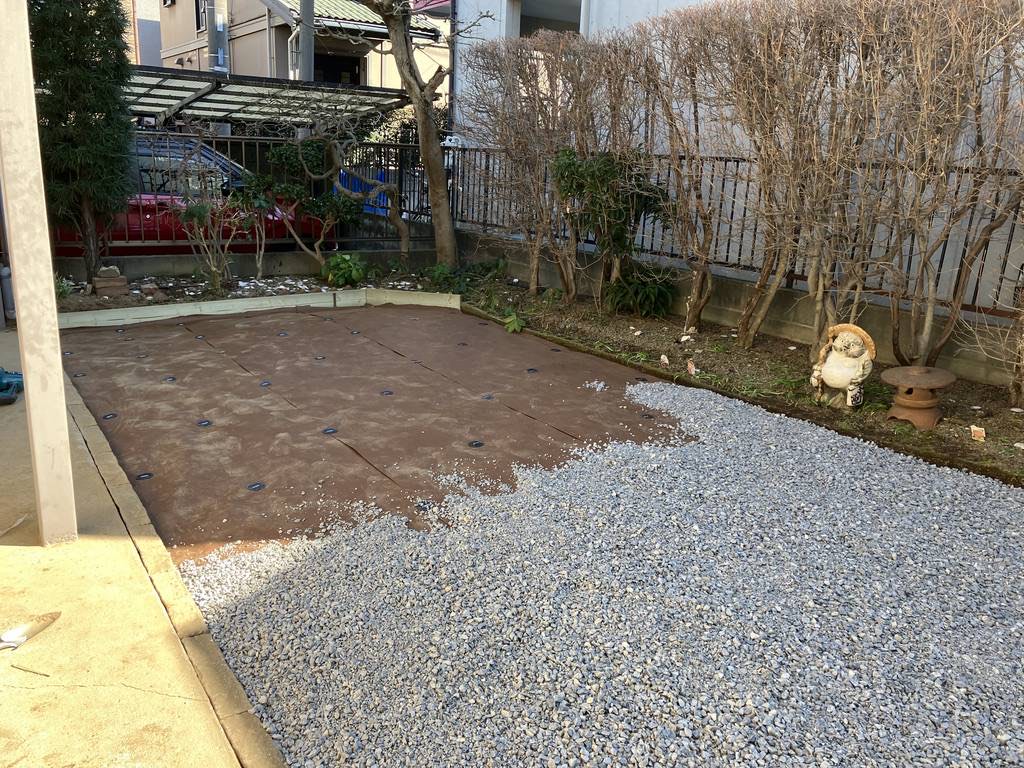 防草シートを敷き、その上に砂利を入れていく途中の庭